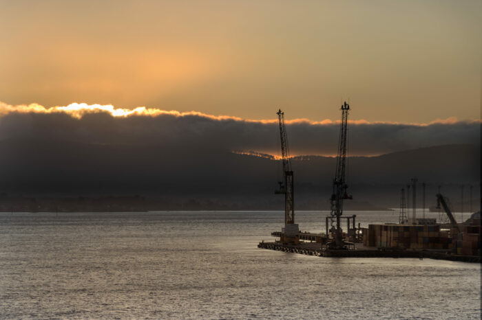 Two shipping cranes at the Bell Bay port in Tasmania at sunset, Australia